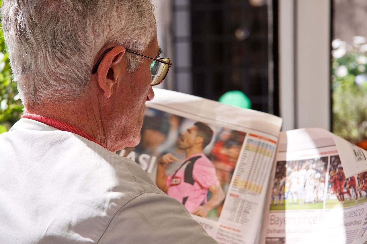 old man reads newspaper